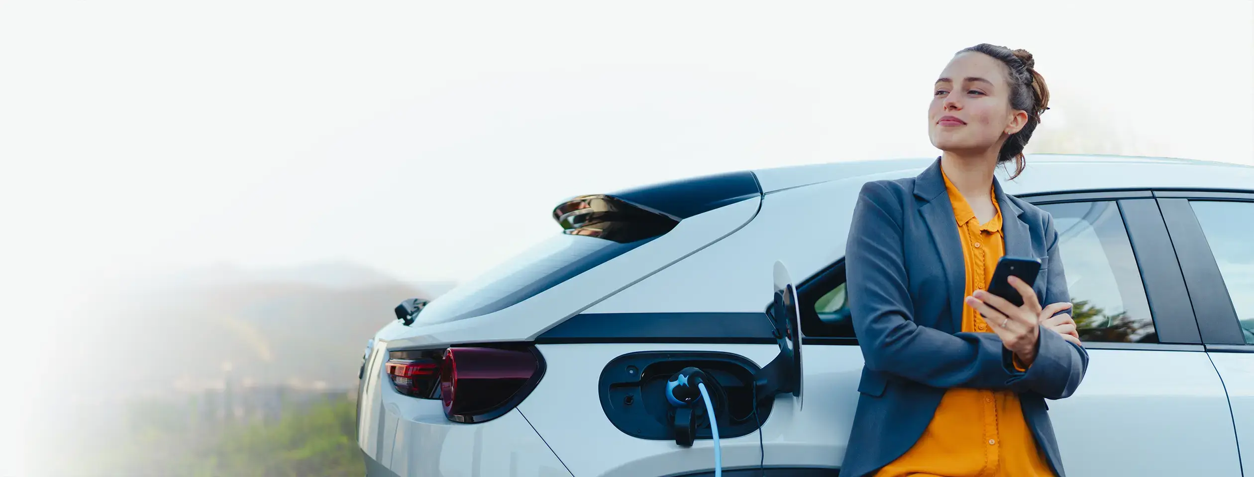 Woman holding phone by car